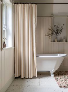 a bath tub sitting next to a window in a bathroom