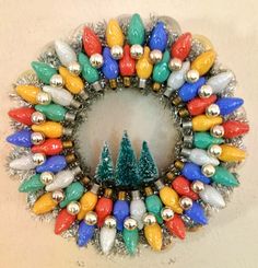 a wreath with christmas lights and trees on it