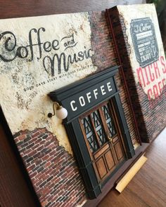 a coffee shop sign on the side of a brick building with an open door and window