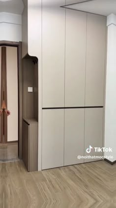 an empty room with white cabinets and wood flooring