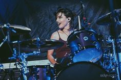 a woman is playing drums on stage