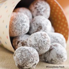 powdered donuts in a paper container on a table