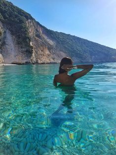 a woman is swimming in the clear water