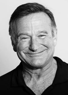 a black and white photo of a smiling man