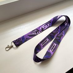 a lanyard with a purple and black design on it, sitting on top of a table