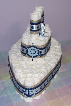 a three tiered cake is decorated with blue and white ribbons on it's sides