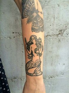 a woman's arm with tattoos on it and a bird flying over her head