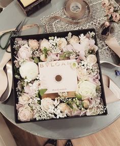 an open box filled with flowers on top of a table