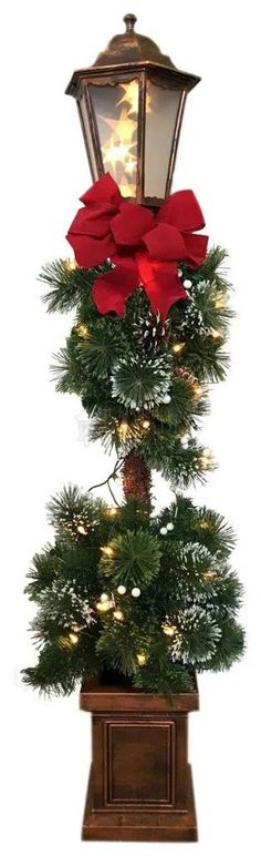 a christmas tree with poinsettis and lights on it in a potted planter