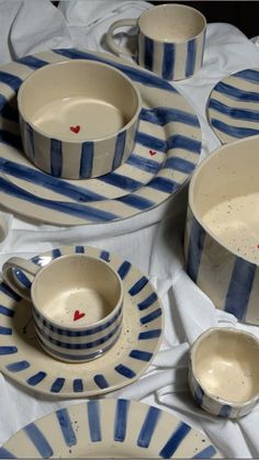 blue and white striped dinnerware set on a tablecloth with red hearts in the center