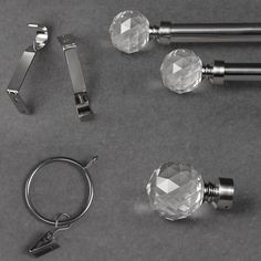 three glass door knobs and two metal handles on a gray surface with key rings