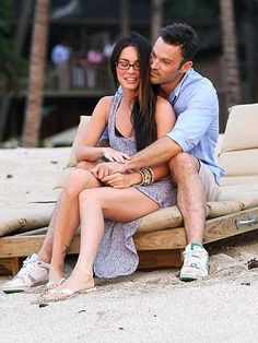 a man and woman sitting on a wooden bench