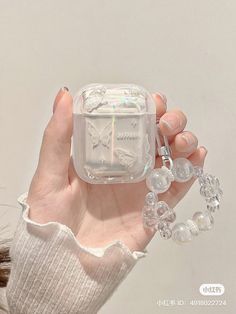 a person holding a small clear box with a clock on it's side and beads around the edges