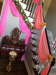 a staircase decorated with pink drapes and flowers