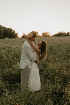 a man holding a woman in the middle of a field