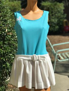 Here is a vintage 1970s tennis dress.Following are the measurements. Bust 36",waist 32",Hips full with pleats,length 29".Made out of polyester fabric .Bodice is a solid stripe turquoise fabric. Skirt has pleats with a belt.In nice vintage condition. Please take special consideration of measurements. 1970s sizing was very small to today's standards. Tennis dresses were very short not like a regular dress. So please take special note of length. If you live overseas please email me first before purchasing for mailing cost. Price quoted is for USA only Vintage Tennis Dress, Summer Pleated Tennis Dress, Blue Spring Tennis Dress, Fitted Spring Tennis Dress With Pleated Hem, Pleated Tennis Dress For Summer, Fitted Tennis Dress With Pleated Hem For Spring, Summer Tennis Dress With Pleated Skirt, Vintage Pleated Summer Dress, Vintage Summer Dress With Pleated Skirt