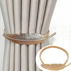 a gold metal feather on a curtain rod