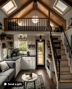 a living room and kitchen area in a tiny home with stairs leading up to the second floor