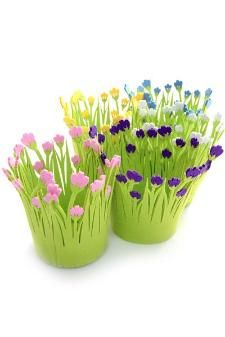 three green flower pots filled with colorful flowers