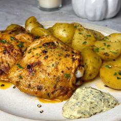 a white plate topped with chicken and potatoes