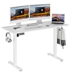 two computer monitors sitting on top of a white desk