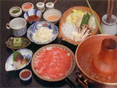 a table topped with lots of different types of dishes and bowls filled with sauces