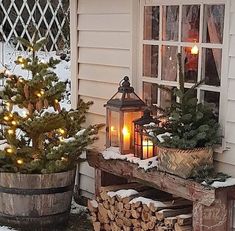 a small christmas tree sitting next to a pile of logs in front of a window