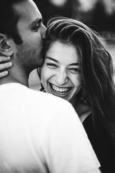 black and white photograph of a man kissing a woman