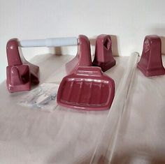 three pieces of pink plastic sitting on top of a bed