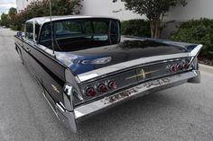 an old black car parked on the street