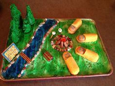 a birthday cake with hot dogs and marshmallows in the shape of a river