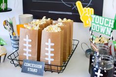 a table topped with brown paper bags filled with popcorn