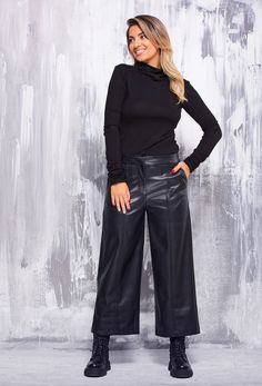 "These faux leather pants are a true symbol of elegance and retro style, inspired by the unique era of the 90s. Its calf-length length lends a casual yet impactful charm. The front zip fastening and hidden button ensure a perfect fit and accentuate the contours of the body. The front pockets add practicality, while the masterfully recreated back pockets are an elegant imitation with subtle detailing on the fillets. The slightly flared legs with the front decorative seam give the trousers character and uniqueness. Made of supple and soft synthetic leather, it provides all-day comfort and freedom of movement. The possibility to choose from several colors makes it a universal choice for any fashion combination. This pant is a true symbol of aesthetics and style that brings to life the spirit Caprese Pants Outfits, Capri Wide Leg Pants Outfit, Cropped Faux Leather Pants Outfit, Faux Leather Wide Leg Pants For Fall, Faux Leather Wide-leg Pants For Fall, Fall Wide-leg Faux Leather Pants, Trendy Faux Leather Wide-leg Pants, Trendy Wide-leg Faux Leather Pants, Fall Wide Leg Faux Leather Pants