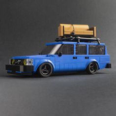 a toy van with luggage on top is shown in front of a gray background,