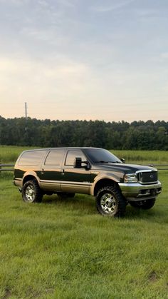 a large truck parked on top of a lush green field