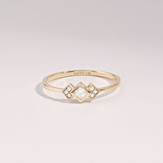 a gold ring with two diamonds on it