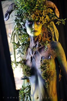 a woman with horns and plants on her head