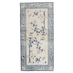 an antique rug with blue and white designs on it, in the shape of a rectangle