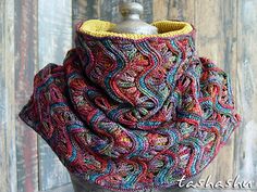 a multicolored knitted cowl with a metal bottle holder on the top