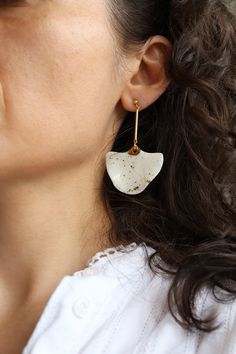 a close up of a person wearing some kind of earring with something white on it