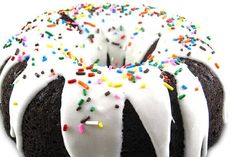 a chocolate bundt cake with white frosting and sprinkles on top