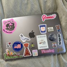 an apple laptop covered in stickers and magnets