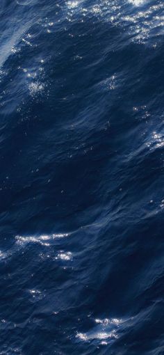 an airplane flying over the ocean on a sunny day