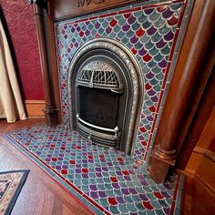 an ornate fireplace in a room with red and blue tiles on the walls, along with wood flooring