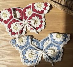 two crocheted butterflies sitting on top of a wooden table