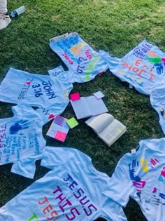 a group of t - shirts with writing on them laying in the grass