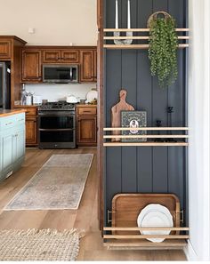 a kitchen with blue walls and wooden cabinets, white plates and utensils on the shelves