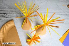 paper plates with orange and yellow decorations on them next to pencils, scissors and other crafting supplies