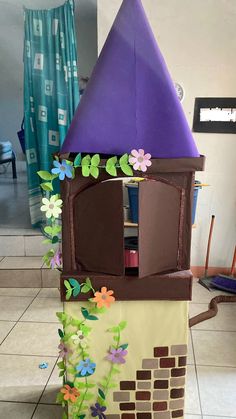 a cardboard castle made to look like it has flowers growing out of the roof and windows