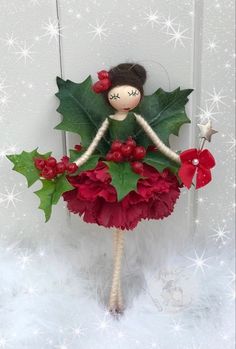 a doll with holly and red flowers on it's body is standing in the snow